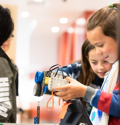 Innovation Center Summer Programming with picture of students working on a robot.
