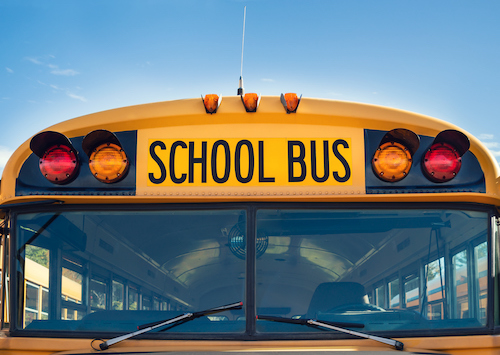 Front view of a yellow school bus with the words "SCHOOL BUS" displayed prominently above the windshield.